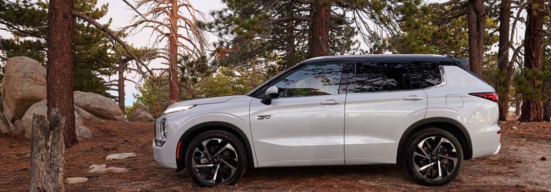 White 2024 Mitsubishi Outlander Plug-In Hybrid Parked in Forest