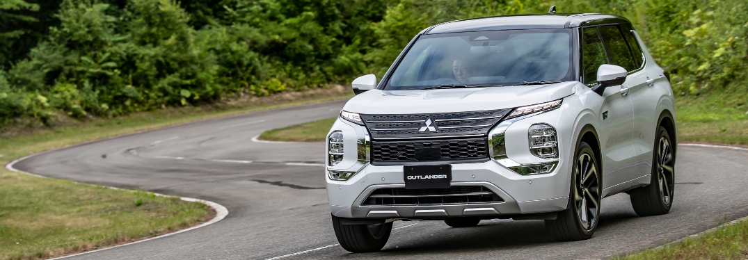 White 2023 Mitsubishi Outlander Plug-In Hybrid Driving on Curved Road